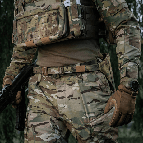 M-Tac Siddeunderlag med Bælte – Multicam på soldat i feltovertøj, camoufleret til maksimale klima- og følebeskyttelse.