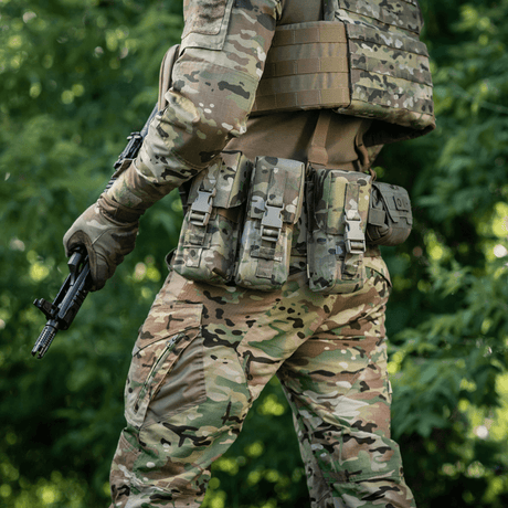 Man in camouflage gear wearing M-Tac Double Magazine Pouch with Fastex Closure, ready for military and security activities in the forest