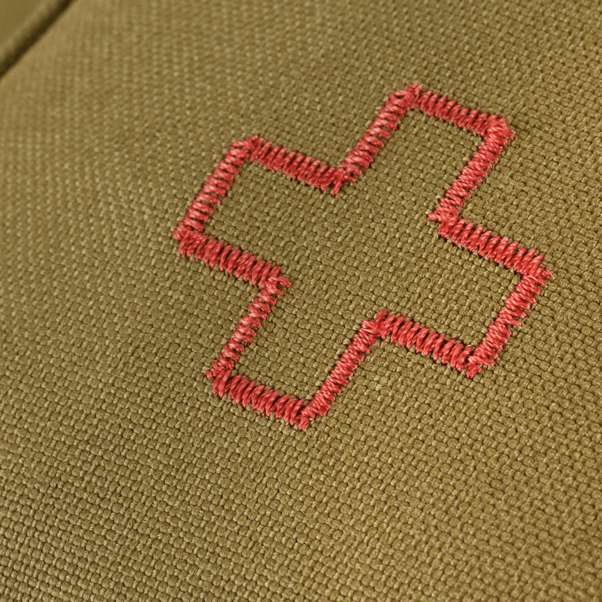 Nærbillede af M-Tac Medical Pouch Rip Off med rødt korsbroderi på olivengrøn baggrund, designet til førstehjælp og hurtig adgang.