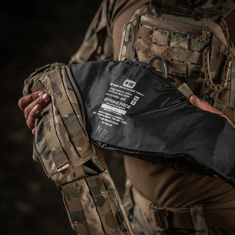 Person holding M-Tac War Belt ARMOR with MOLLE webbing and robust materials, ideal for tactical use.