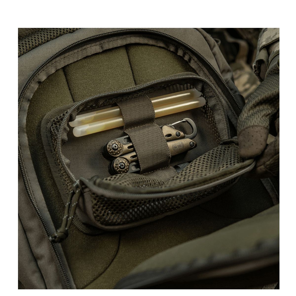 M-Tac Hook & Loop Utility Panel indvendigt i en taske, viser lynlåslomme med organiserede værktøjer. Stift rektangulært panel i brug.