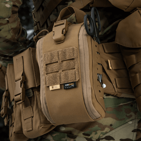 M-Tac Medical Pouch Elite Rip Off fastgjort til feltudstyr, taktisk medicinsk førstehjælpstaske i brug, med elastiske stropper.