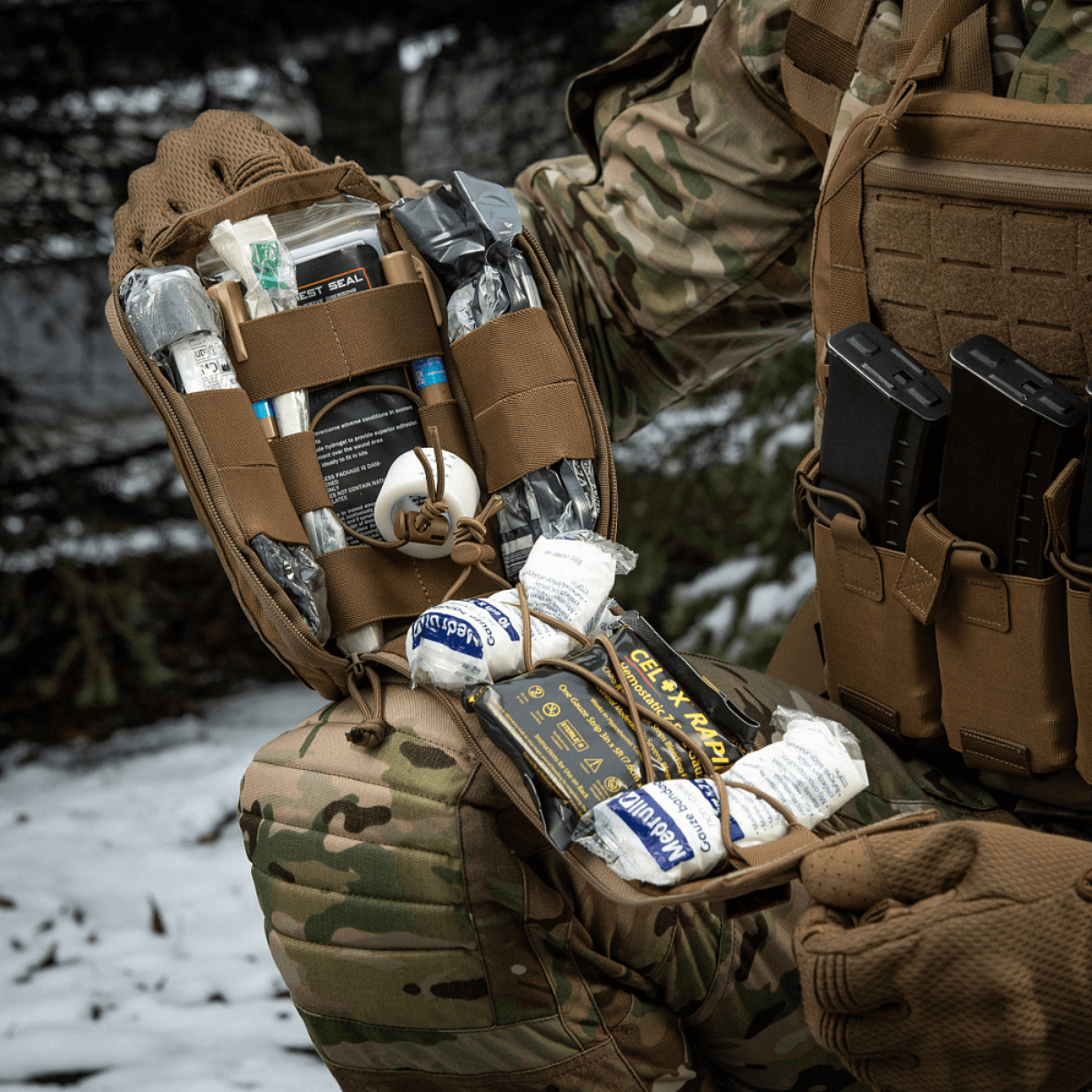M-Tac Medical Pouch Elite Rip Off i brug af soldat i sne, åben taske med indhold tydeligt organiseret og klar til hurtig adgang.