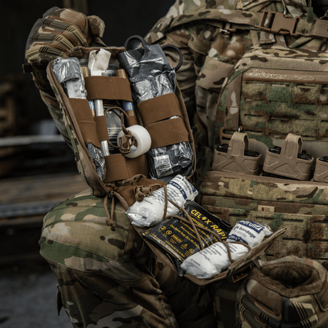 M-Tac Medical Pouch Elite Rip Off med indhold, der er organiseret med elastiske stropper til hurtig og effektiv brug i nødsituationer.