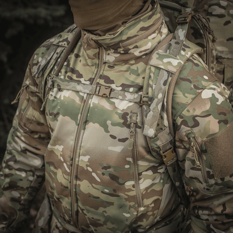 Camouflage-jakke båret af en person, der bærer M-Tac Rygsæk Large Gen.III Elite, velegnet til taktisk brug og udstyrstransport.