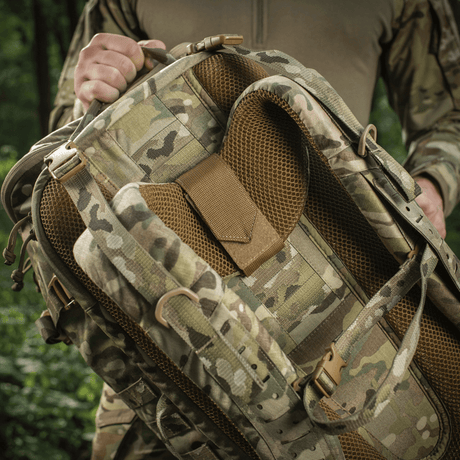 M-Tac Rygsæk Gen.II Elite Large i camo-design, holdt af en person, viser ergonomisk design og høj slidstyrke.