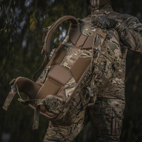 M-Tac Large Gen.IV Elite in camo pattern, ergonomic design, held by a person in military clothing in a natural environment.
