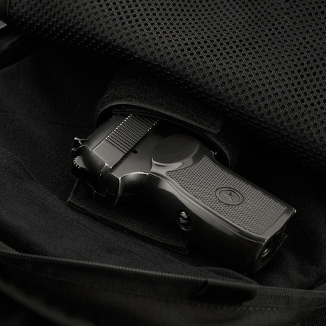 Interior compartment of M-Tac Magnet XL Bag Elite with universal holster shown with a pistol.