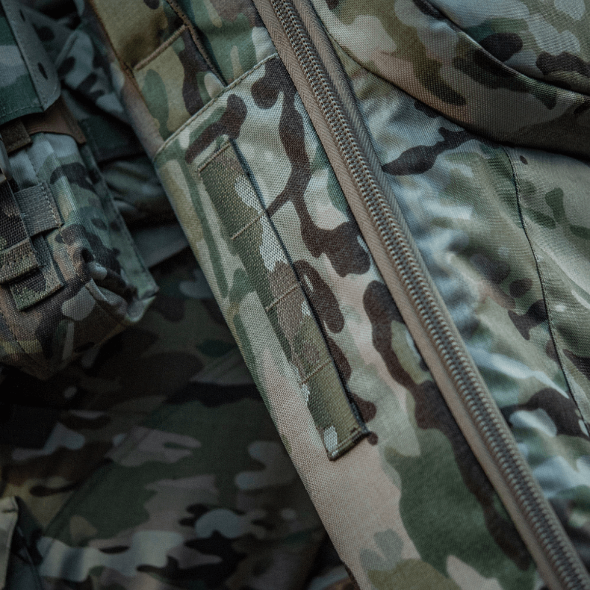 Detalje af M-Tac Gun Backpack Case 125 cm Gen.II Elite i camouflagestof, der fremhæver Cordura-materiale og lynlås.