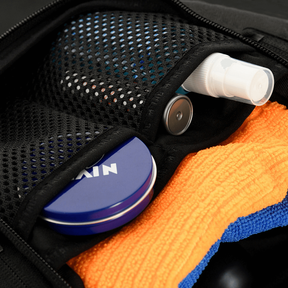 Nærbillede af M-Tac Toilettaske Elite Gen.II med opbevaring af plejeartikler som en beholder, creme og håndklæde.