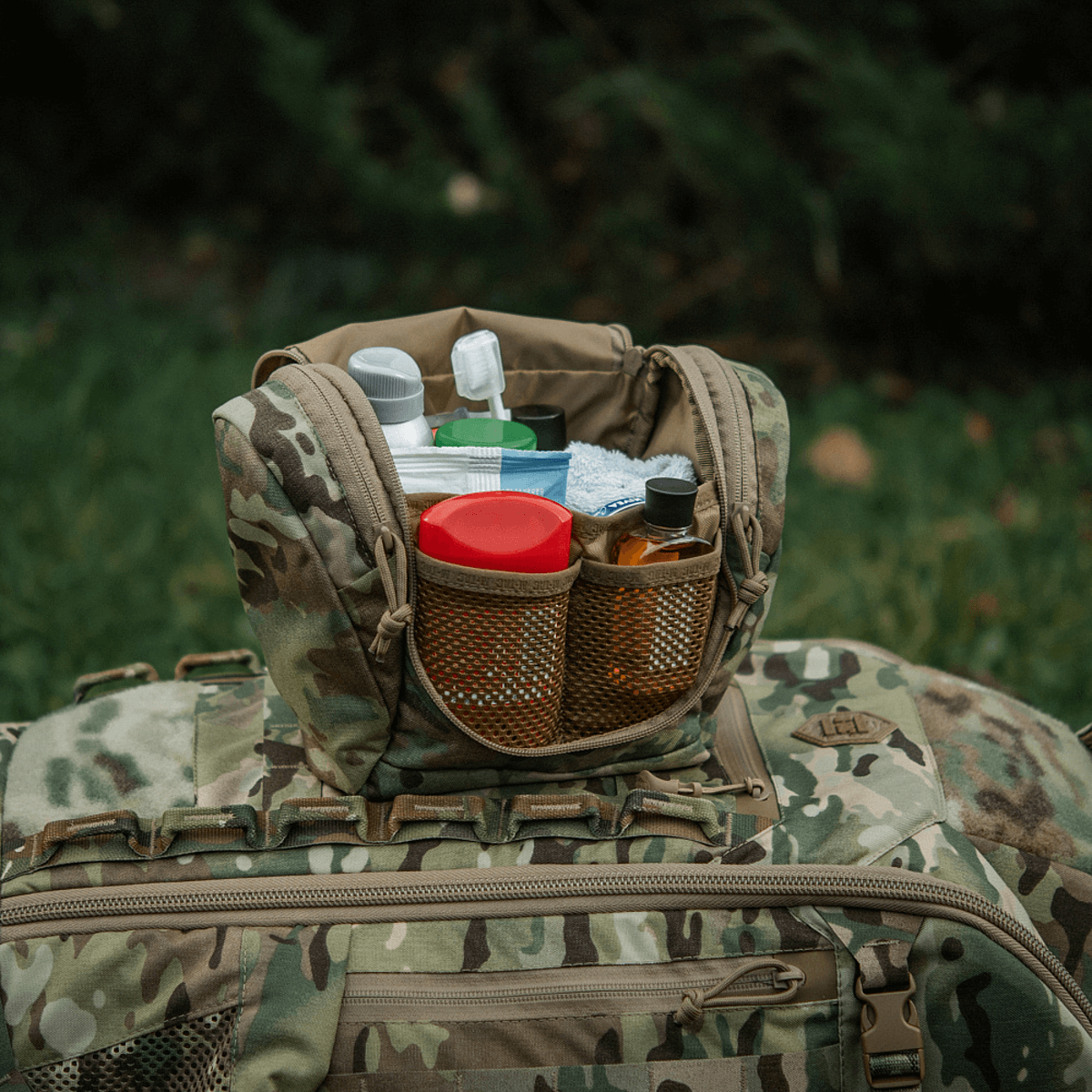 M-Tac Toilettaske Elite Gen.II fyldt med rejseartikler som tandbørste og shampoo, kompakt til opbevaring af hygiejneartikler i felt.