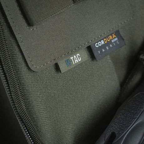Close-up of M-Tac Double Mag Pouch Hook Backed Magazine with Velcro fastening and Cordura label on green fabric
