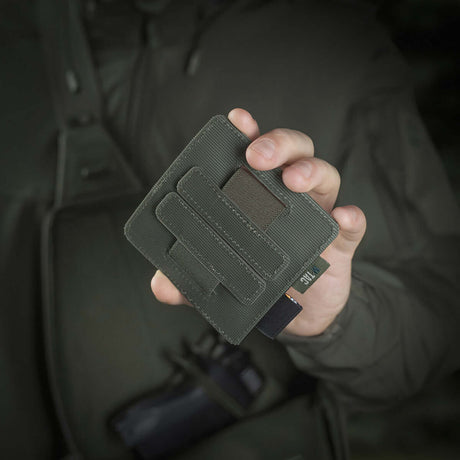 Person holding M-Tac Double Mag Pouch Hook Backed Magazine, ideal for pistol magazines and multitools, attached with Velcro