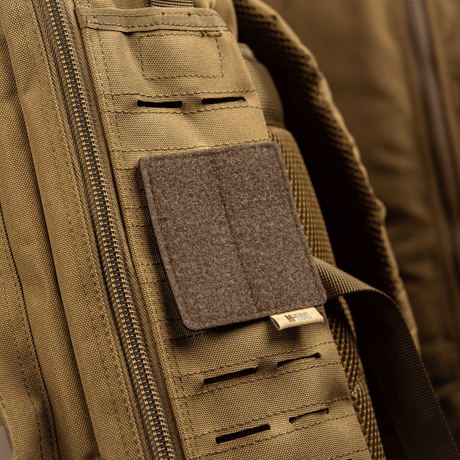 M-Tac MOLLE patch panel 80x85 mm attached to a backpack with hook & loop surface and plastic base for stability.