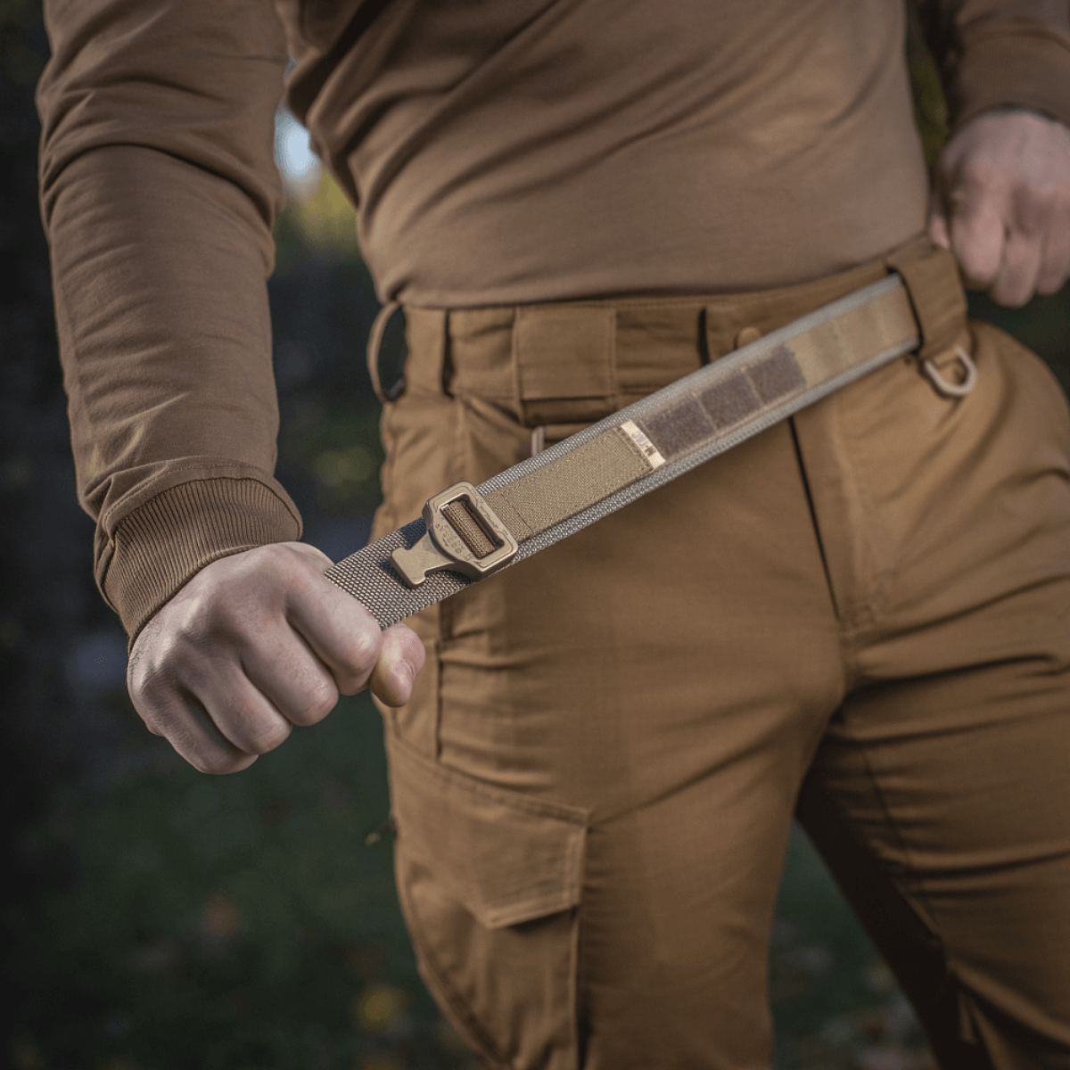 M-Tac Cobra Buckle Taktisk Bælte Laser Cut brugt i militær og politi udstyr, viser bæltedesign og styrke i brun uniform