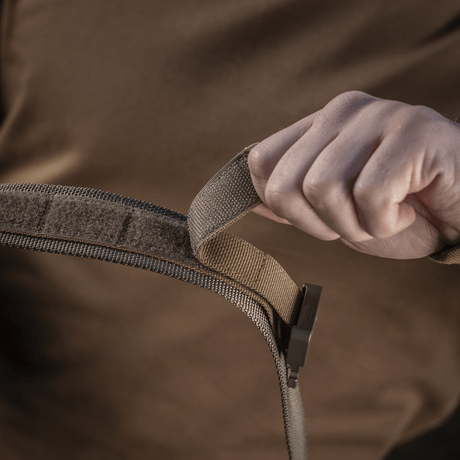 Person demonstrating M-Tac Cobra Buckle Tactical Belt Laser Cut with COBRA buckle and MOLLE interface.