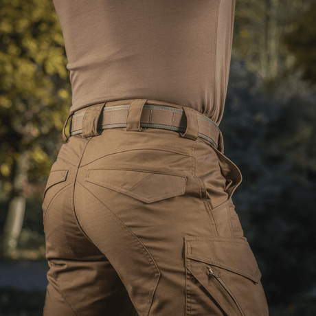 M-Tac Cobra Buckle Tactical Belt Laser Cut, suited for military use, worn with brown trousers in an outdoor setting.