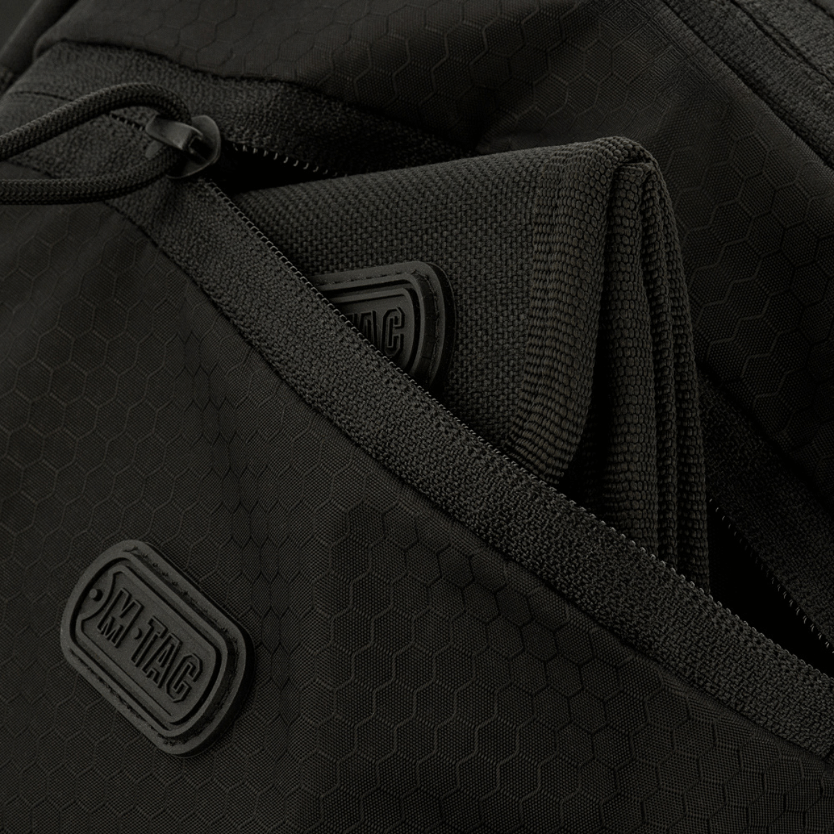 Nærbillede af M-Tac Sphaera Hex Hardsling Bag med lynlåskompartments og M-Tac mærke, lavet af holdbar Cordura/Hex polyester.