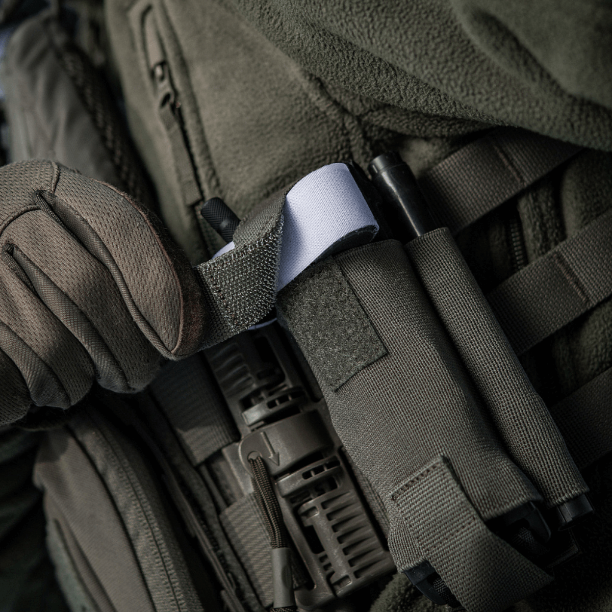 M-Tac Elastisk Tourniquet Pouch Molle Gen.III i brug, sikrer hurtig adgang til tourniquet, lavet af robust Cordura Squadron materiale.