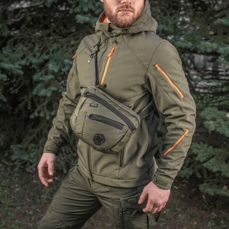 M-Tac Sphaera Hex Hardsling Bag Gen.II Elite on a man wearing military green clothing outdoors.