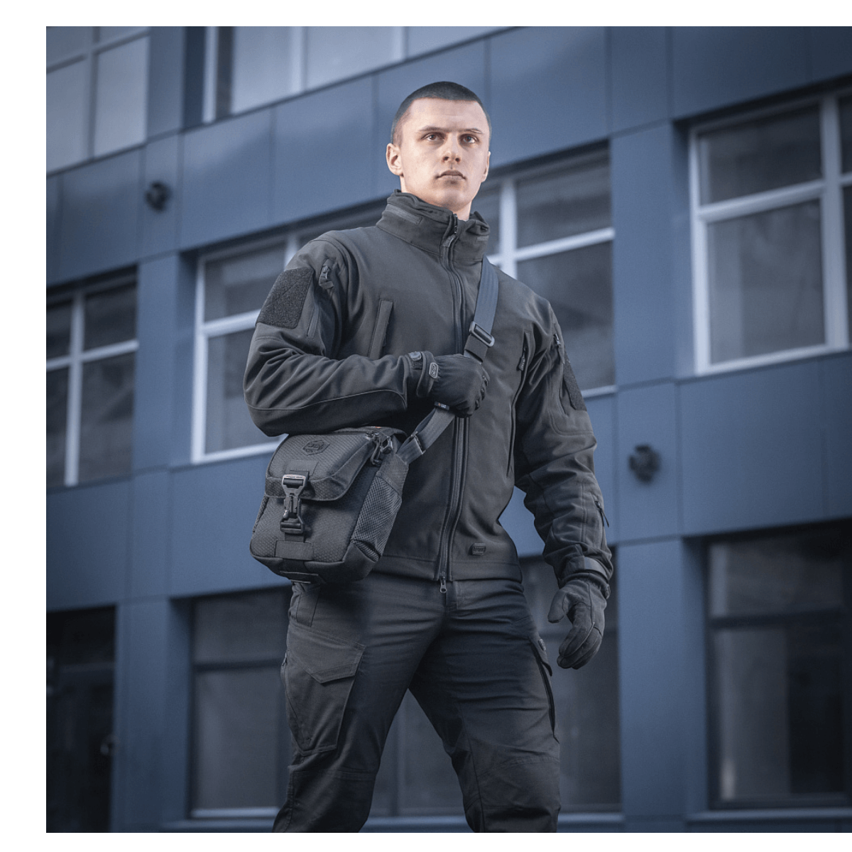 Mand bærer M-Tac Satellite Magnettaske Gen. II Elite Hex i sort foran en bygning