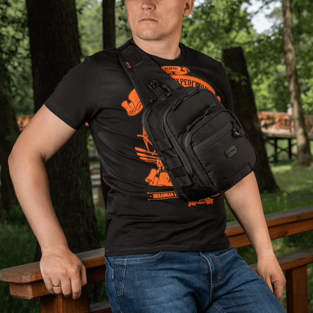 Mand iført M‑Tac Cross Bag Elite Hex, en sling-pack taske af Cordura 500, perfekt til daglig brug og taktisk udstyr.