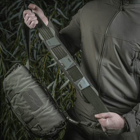 Man holding M-Tac Shoulder Strap Pad 50 mm Elite mounted on a bag.