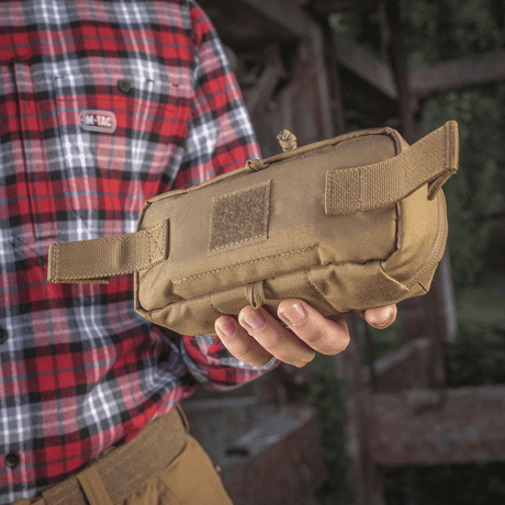 M-Tac Horizontal Medical Pouch Elite i hånden på en person, holdbar feltkit til førstehjælp med indre organizer og vandtæt lynlås.