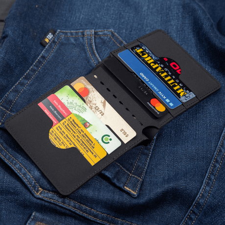 M-Tac Slim Elite wallet in modern polymer composite, showing cards and cash, lying on blue denim. Stylish and durable wallet.