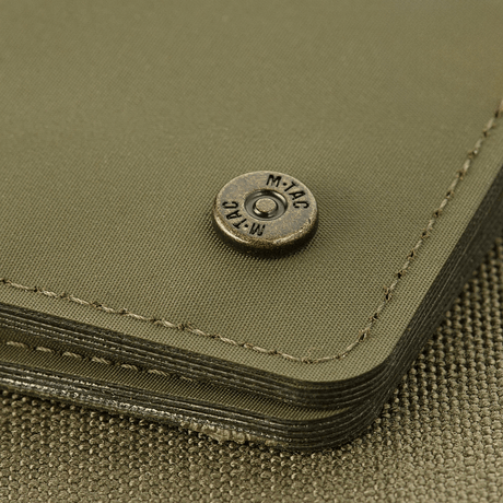M-Tac Slim Elite with branded brass stud, showing wear-resistant modern polymer composite, compact green design.