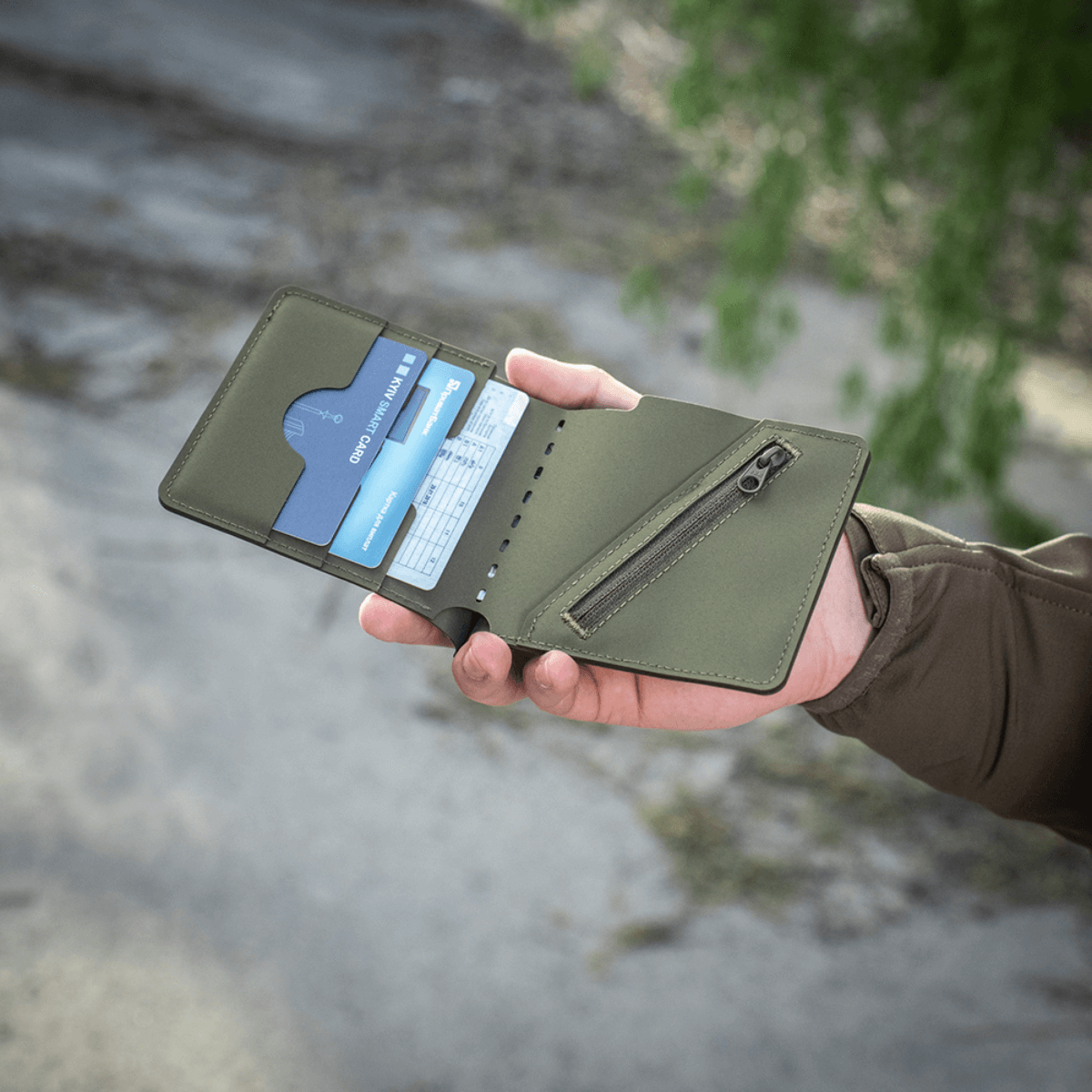 M-Tac Pung Slim Elite Gen. II holdt i hånd, viser kort og lynlåslomme i kompakt, stilfuldt design.