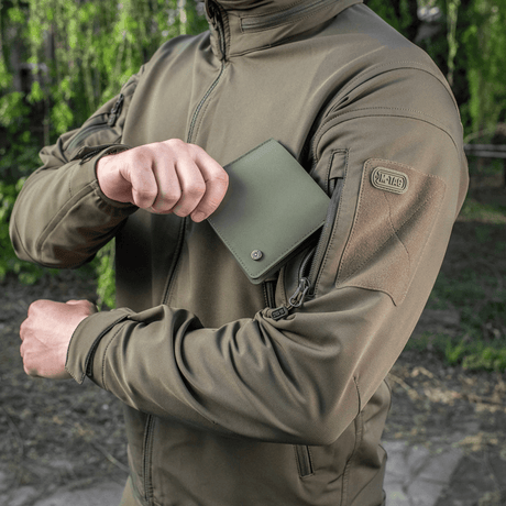 M-Tac Slim Elite Gen. II in green polymer composite held by a person in a jacket, showing compact design and wear resistance.