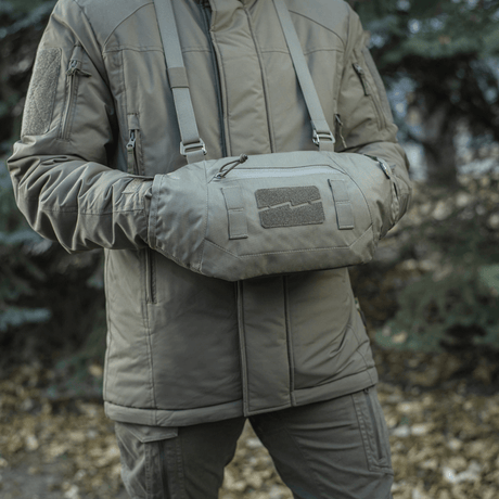 Person iført M-Tac Taktisk Håndvarmer Elite, fremstillet af slidstærkt Cordura 500D med blødt fleecefor, i udendørs naturmiljø.