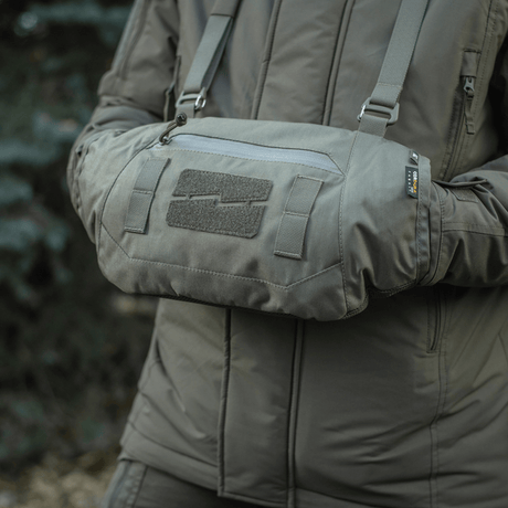 Person bruger M-Tac Taktisk Håndvarmer Elite i grå, fremstillet af Cordura med Polartec fleecefor, ideel til koldt vejr.