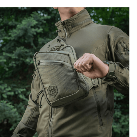 Person wearing M-Tac Sling Pistol Bag Elite Hex outdoors in a comfortable, durable bag with adjustable strap and roomy compartments.