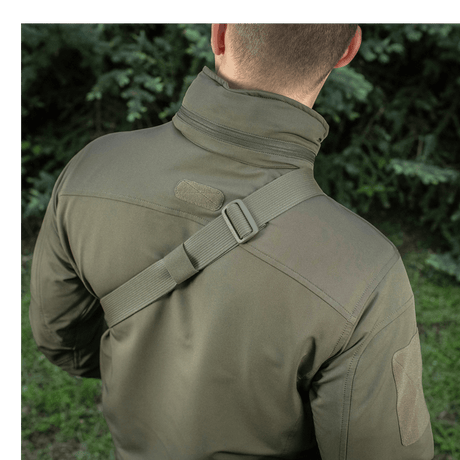 Man wearing M-Tac Sling Pistol Bag Elite Hex with adjustable shoulder strap in an outdoor setting.