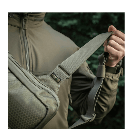 Man wearing M-Tac Sling Pistol Bag Elite Hex with adjustable shoulder strap in Cordura material.