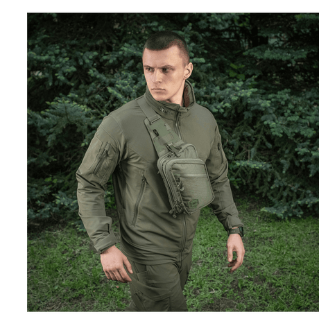 M-Tac Sling Pistol Bag Elite Hex worn by a person outdoors, showing the bag's design and versatility.