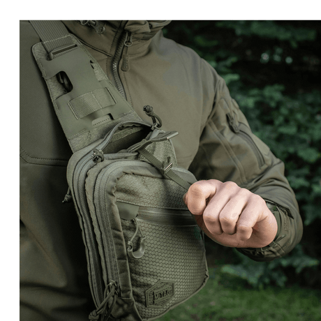 M-Tac Sling Pistol Bag Elite Hex with adjustable shoulder strap on a person outdoors.