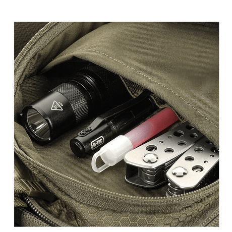 Detail of M-Tac Sling Pistol Bag Elite Hex with flashlight, multitool and pen visible in the pocket.