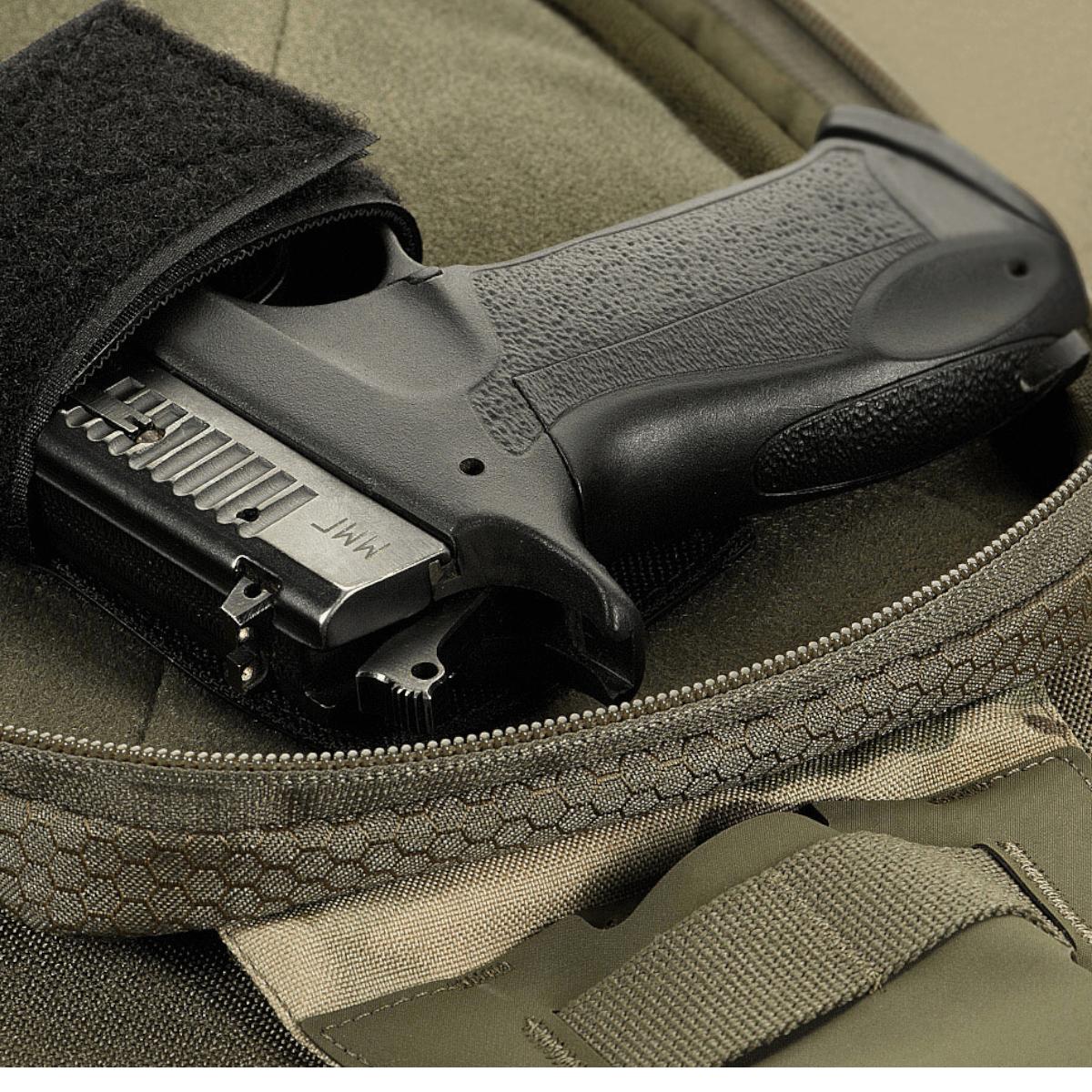 M-Tac Sling Pistoltaske Elite Hex med pistol i et af dens rummelige rum. Tasken i slidstærkt Cordura materiale med YKK lynlås.