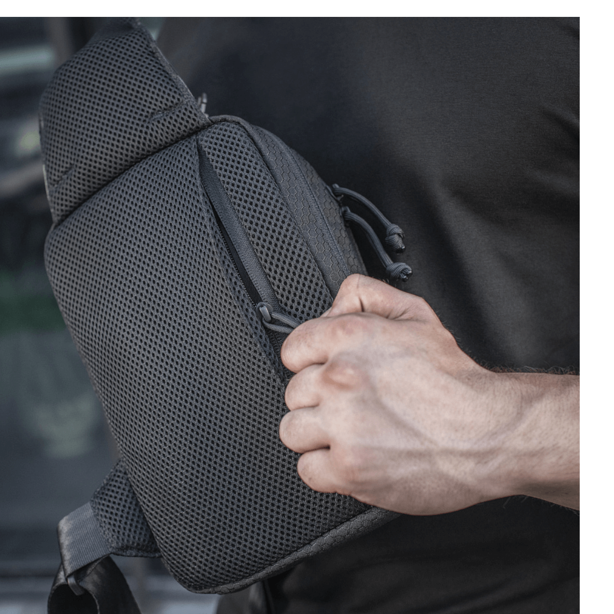 M-Tac Sling Pistoltaske Elite Hex i brug med justerbar skulderrem og rummelige rum, lavet af holdbart Cordura materiale.