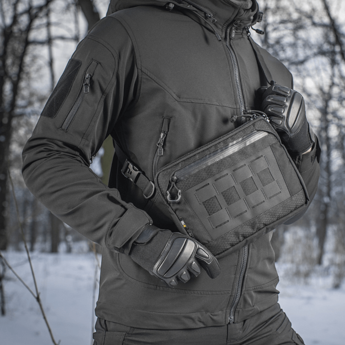 M-Tac Admin Taske Elite i sort, slidstærkt design lavet af Cordura med justerbar skulderrem, vist i vintermiljø.