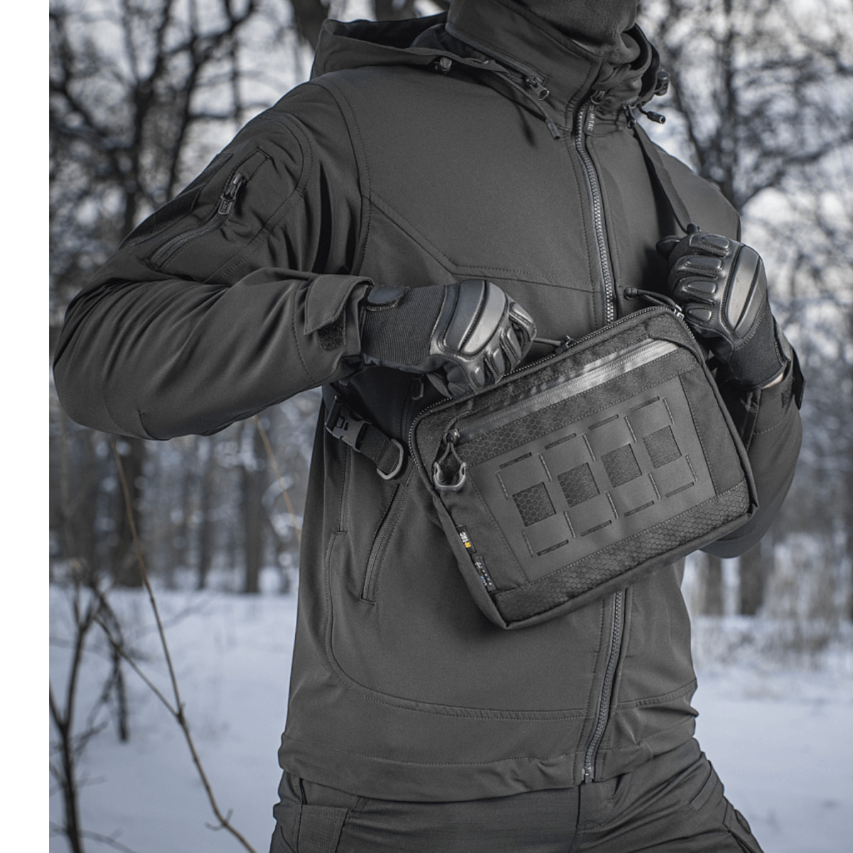 M-Tac Admin Taske Elite bæres af person i vinterudstyr, lavet af slidstærkt Cordura 500D, perfekt til stil og funktionalitet.