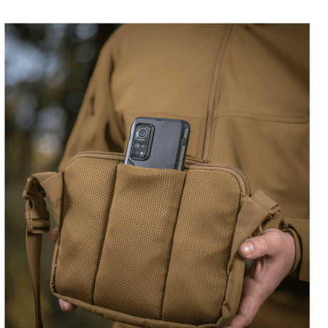 M-Tac Admin Bag Elite with a mobile phone in the pocket, shown outdoors