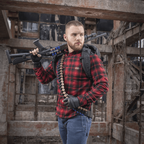 Man wearing M-Tac Bandolier Elite and firearm in an industrial setting, designed for quick access to ammunition.