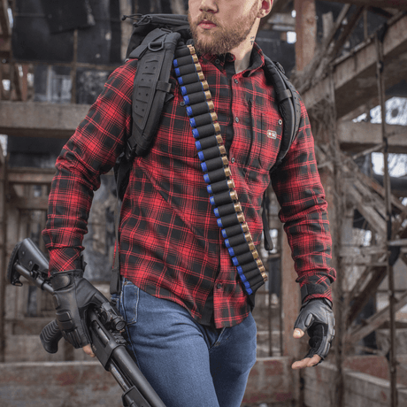Hunter with M-Tac Bandolier Elite loaded with caliber 12/16 shells, ready for hunting in an abandoned building.