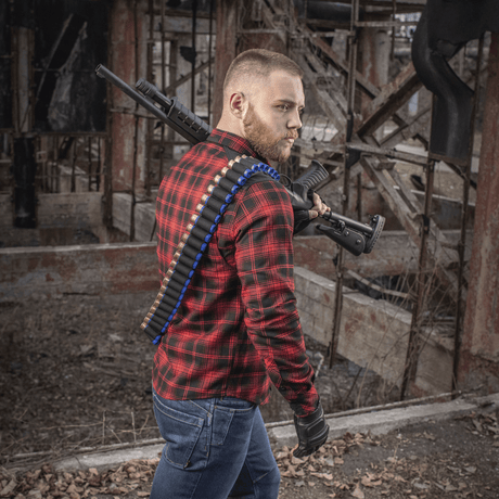 Man wearing M-Tac Bandolier Elite with cartridges, ready for hunting or shooting sports, standing in an industrial environment.