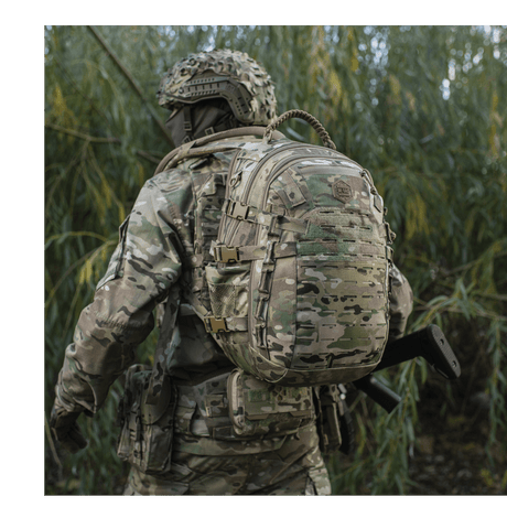 M-Tac Mission Pack Elite backpack in camouflage with MOLLE LASER CUT system in a forest area.