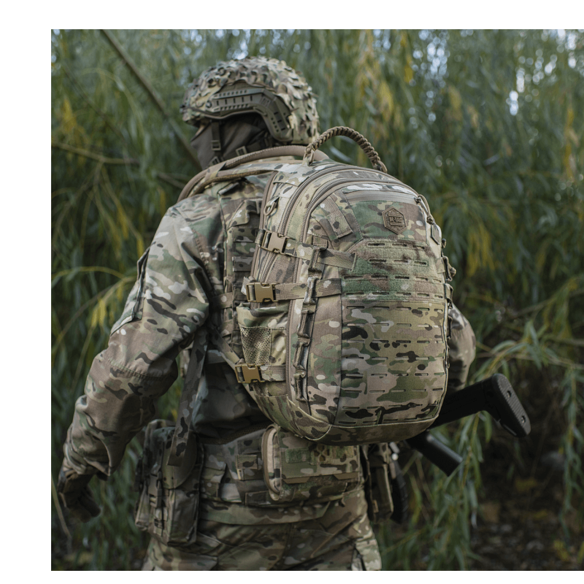 M-Tac Mission Pack Elite rygsæk i camouflage med MOLLE LASER CUT-system i skovområde